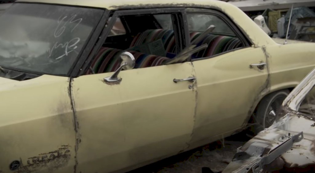 As they sifted through the wreckage of old vehicles, they stumbled upon a 1965 Chevy Impala, a once-iconic representation of American automotive design, now forgotten and left to rust.